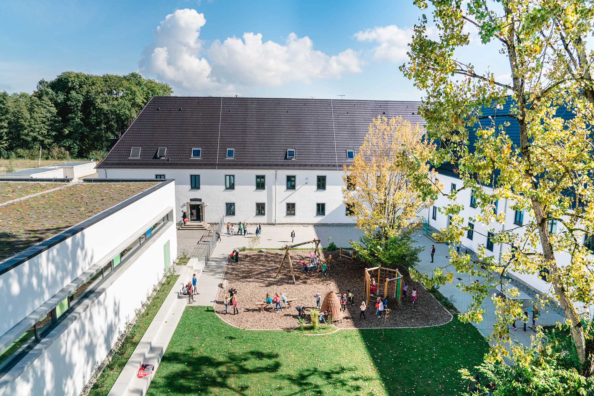 The school building with an inviting playground where children are having fun.