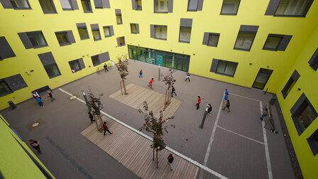 View of the school courtyard from above. Students are playing football there.