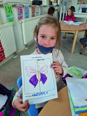 Ein Mädchen zeigt ihren slebst gemalten Schmetterling