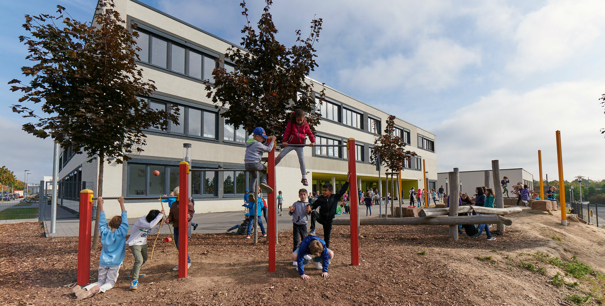 View of the school building from the outside. A playground can be seen in the foreground.